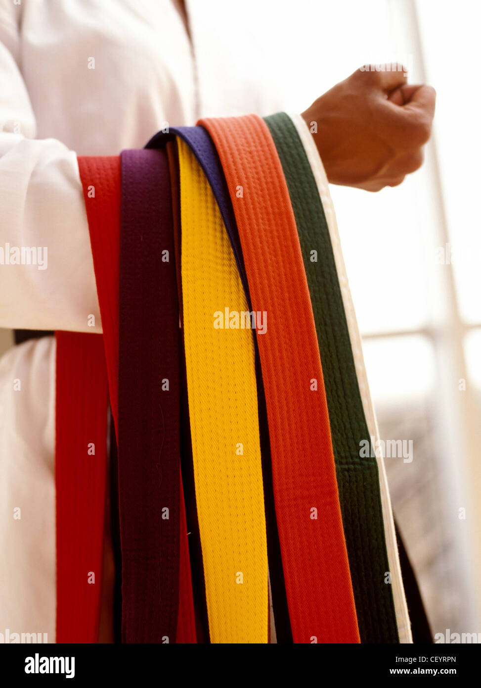 Cropped image of female wearing a white judo suit holding different