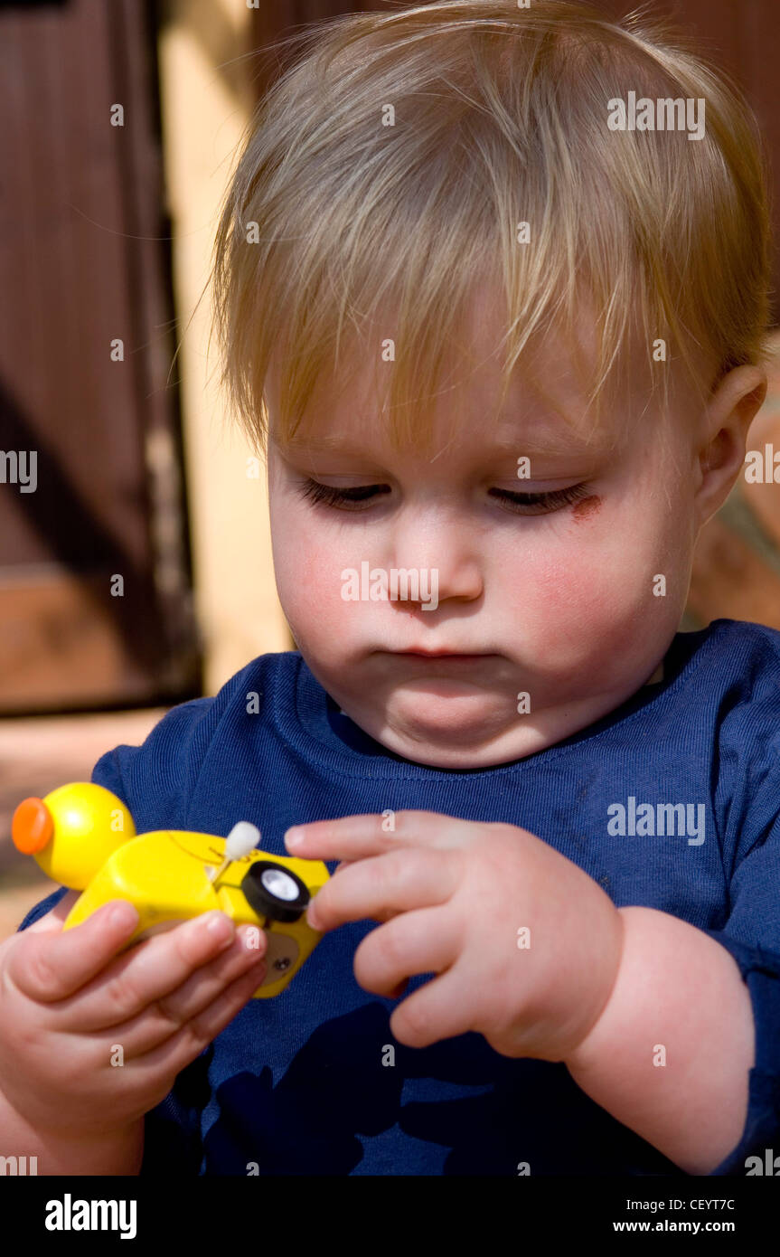 Male child playing with wind up duck toy Stock Photo Alamy