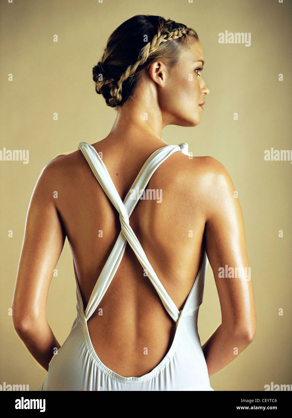 Body Lovely: Lovely Back Back view of female blonde hair worn in a plait and pinned up, wearing a white dress cross straps and Stock Photo