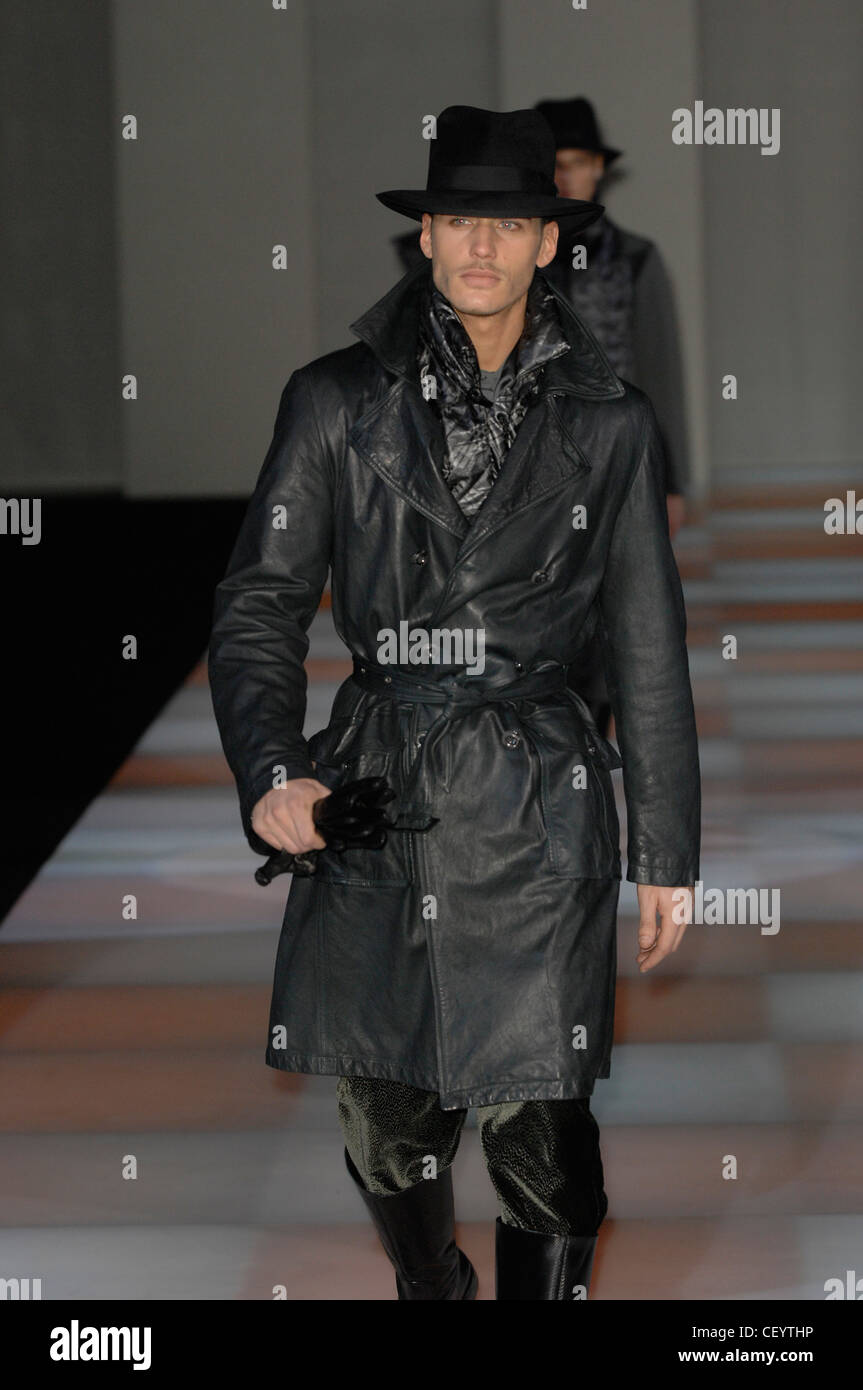 Giorgio Armani Milan Ready to Wear Autumn Winter  Black leather trench coat, velvet trousers, leather gloves, scarf and stetson Stock Photo