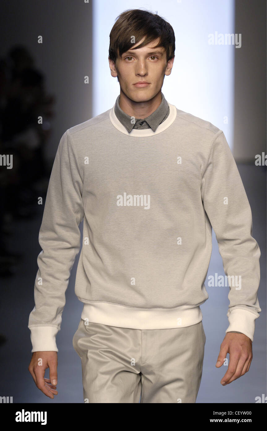 Calvin Klein Milan Ready to Wear Menswear Spring Summer Brunette male model  wearing a grey sweater white trim and a grey shirt Stock Photo - Alamy