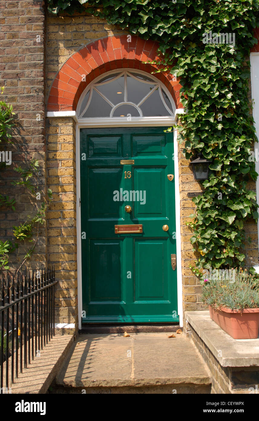 A Green Front Dowith Semi Circle Arched Window Above And Ivy