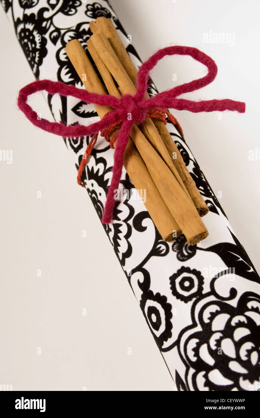 A still life of a tube of black and white flocked wrapping paper, three