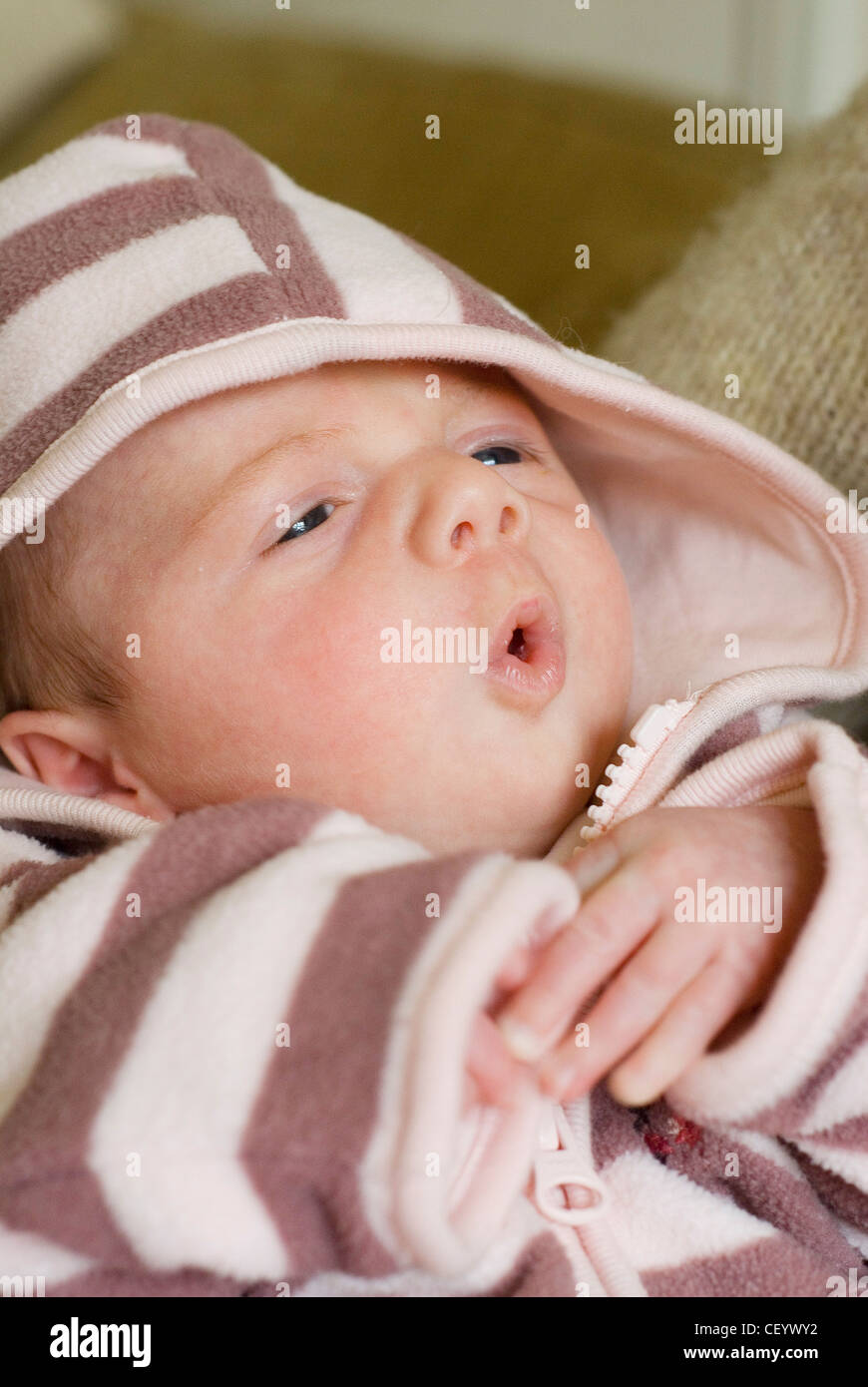 Female two month old baby dressed in a brown and pink striped hooded