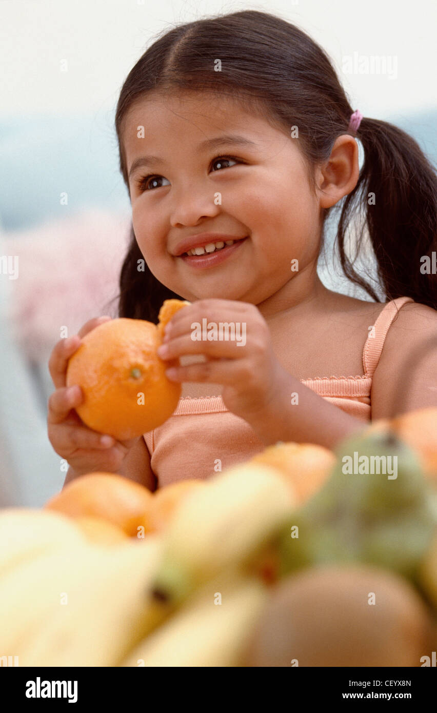 Female toddler hair tied into two ponytails, wearing an orange