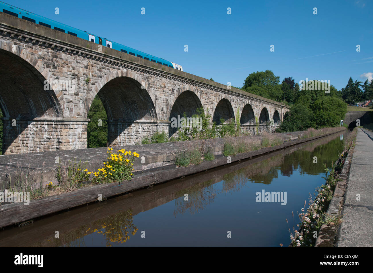 Llangollen canal running crossing over Chirk aquaduct Arriva train running over Chirk viaduct in background. Stock Photo