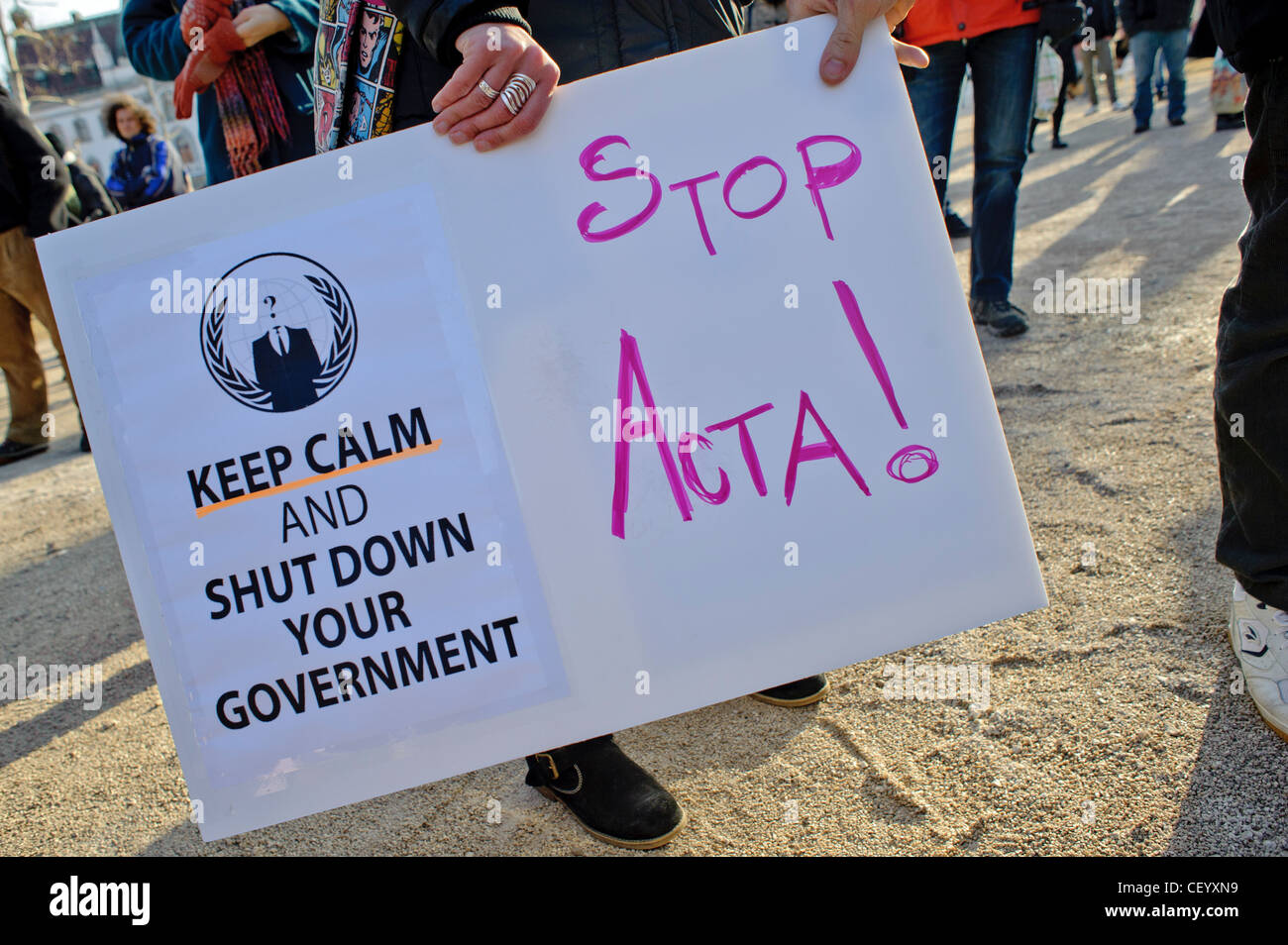 Protesters hold up a sign that reads 'Keep calm and shut down your government' and 'Stop ACTA!' Stock Photo