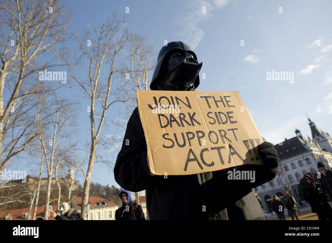 A protester dressed up as Darth Vader holds a sign that reads 'Join the dark side support ACTA'. Stock Photo
