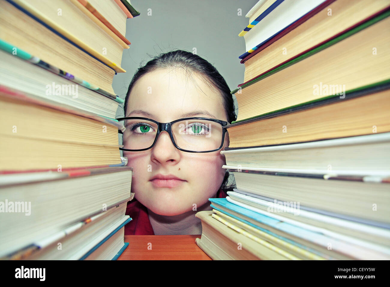 portrait of a girl peeping from the books Stock Photo