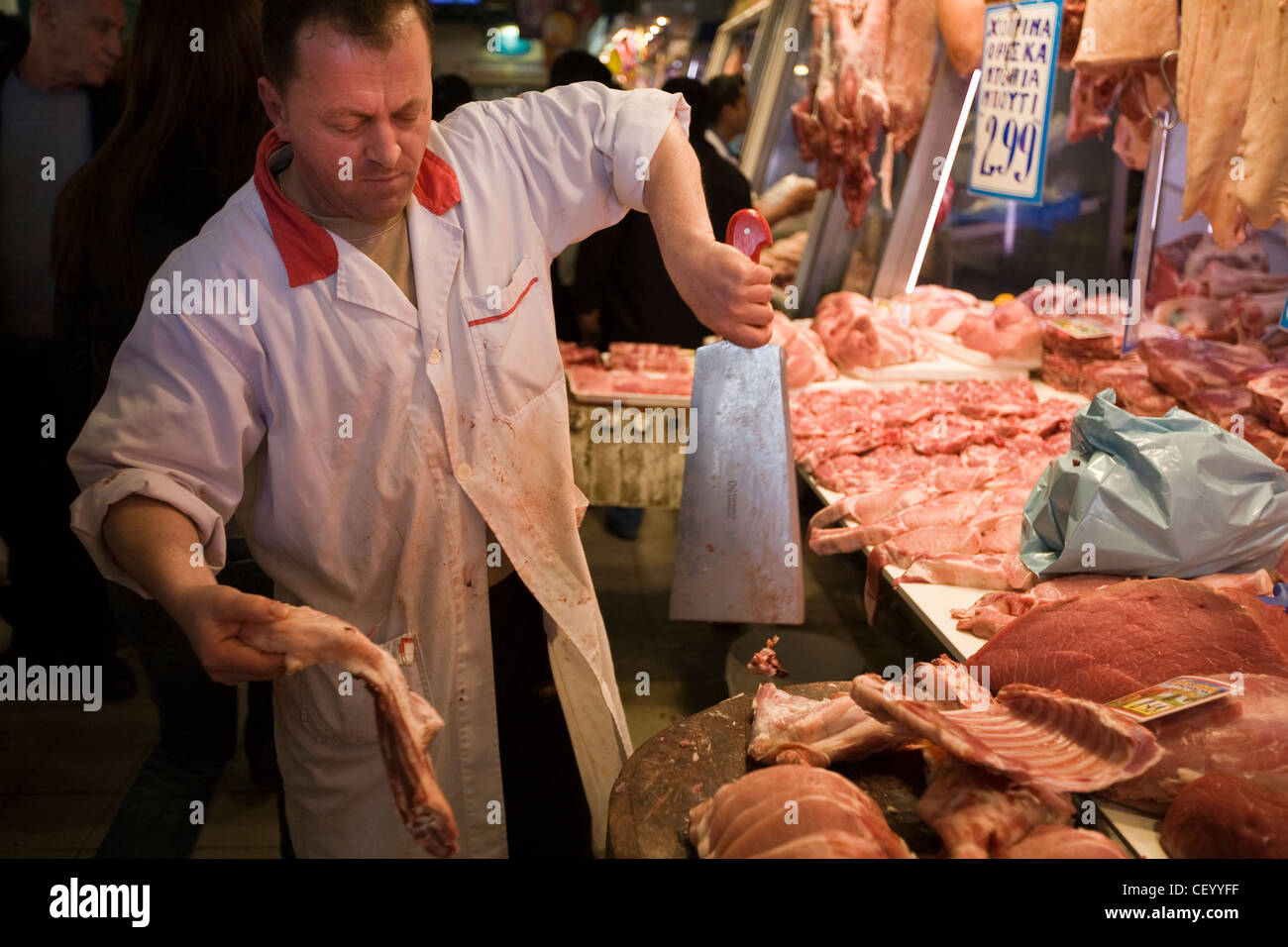 A butchers chops a carcass of meat in the Athens Central Market on Athinas Street. Athens, Greece Stock Photo