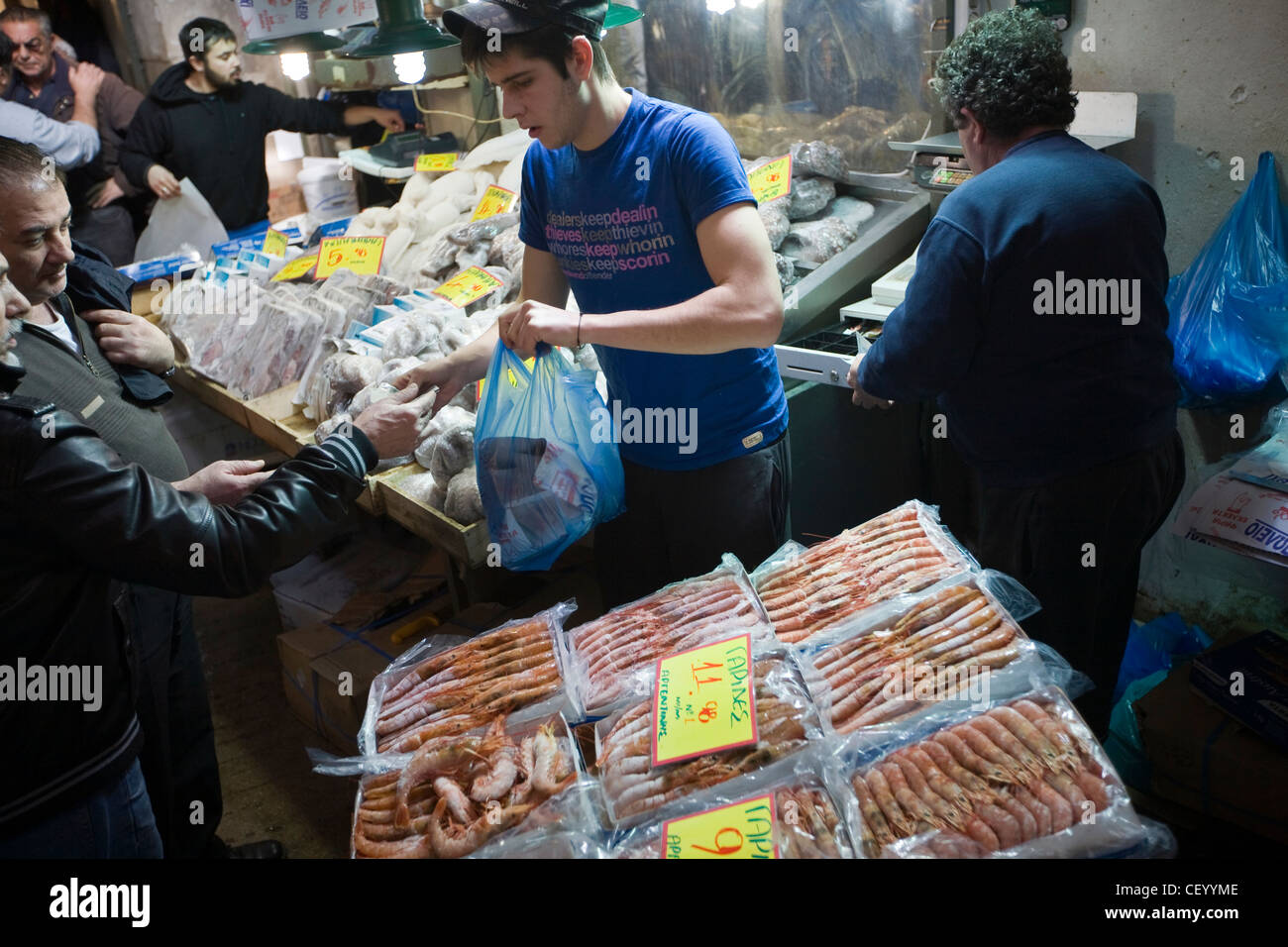 A fishmonger serves a customer at his stall in the Athens Central Market on Athinas Street. Athens, Greece Stock Photo