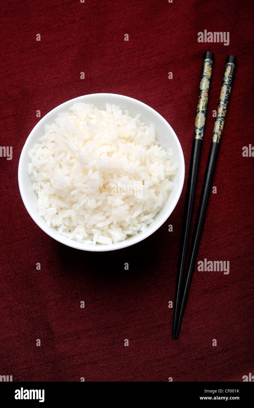 A bowl of boiled rice, with black patterned chopsticks Stock Photo
