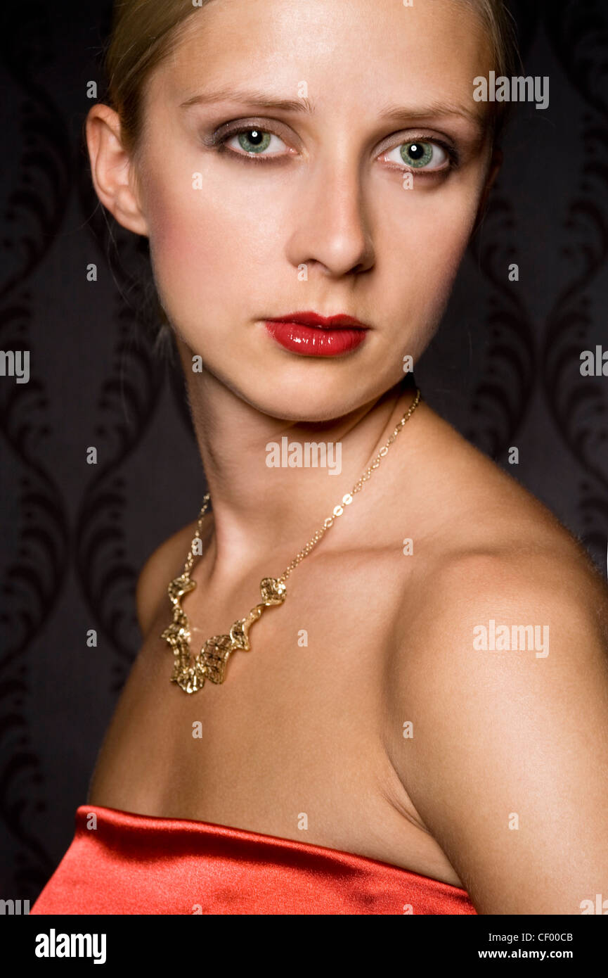elegant woman wearing golden jewelry, over wallpaper background Stock Photo
