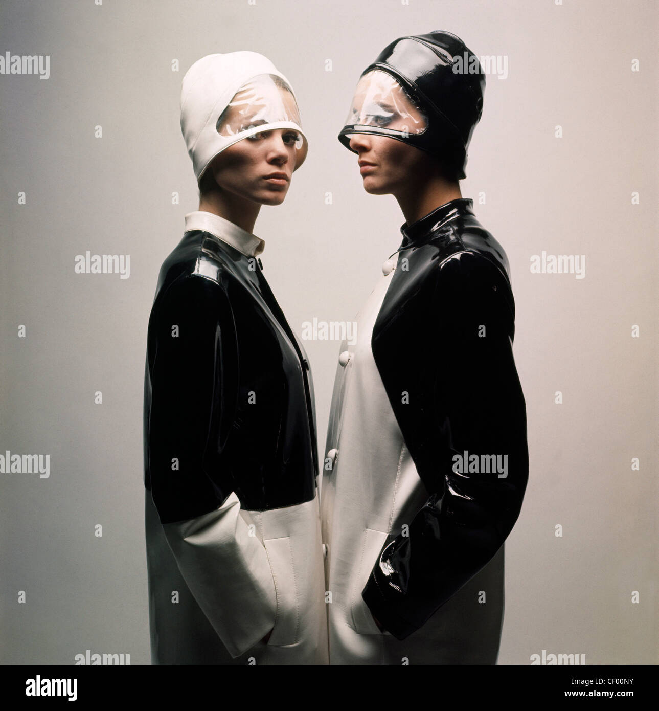 s Fashion Futuristic Monochrome: Two females facing each other, both wearing black and white PVC coats and matching veiled Stock Photo