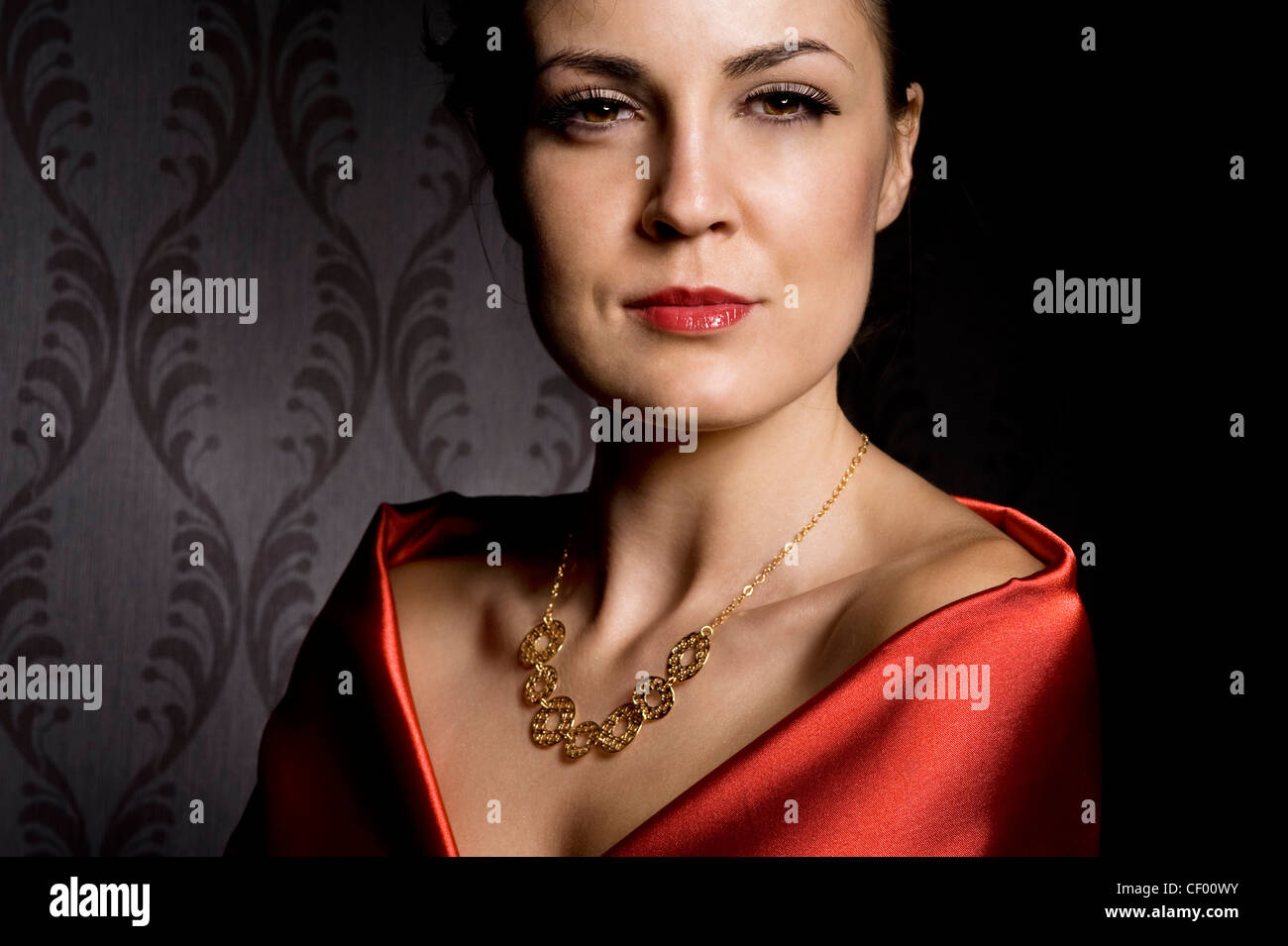 woman wearing golden necklace over wallpaper background Stock Photo