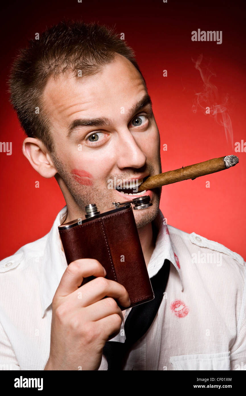 young confident man with hip flask and cigar Stock Photo