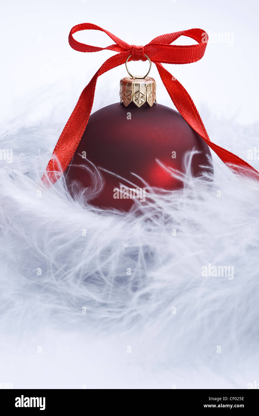 christms ball with decorative red ribbon on feather Stock Photo