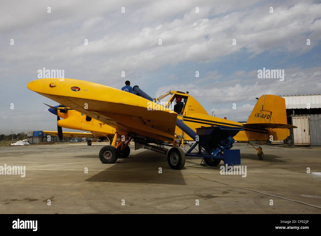 Ground crew preparing an Ayres S2R-T45 Turbo Thrush agricultural aircraft for spraying dusting chemicals over agricultural field in Sde Teiman airfield in southern Israel Stock Photo