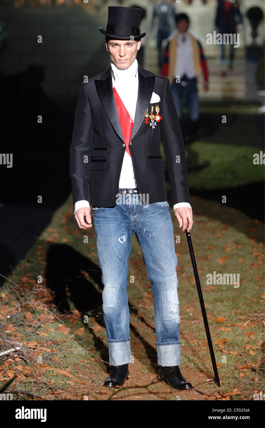 D Menswear Milan A W Male wearing a fitted black tuxedo jacket over a white  shirt diagonal red stripe tucked into blue jeans Stock Photo - Alamy