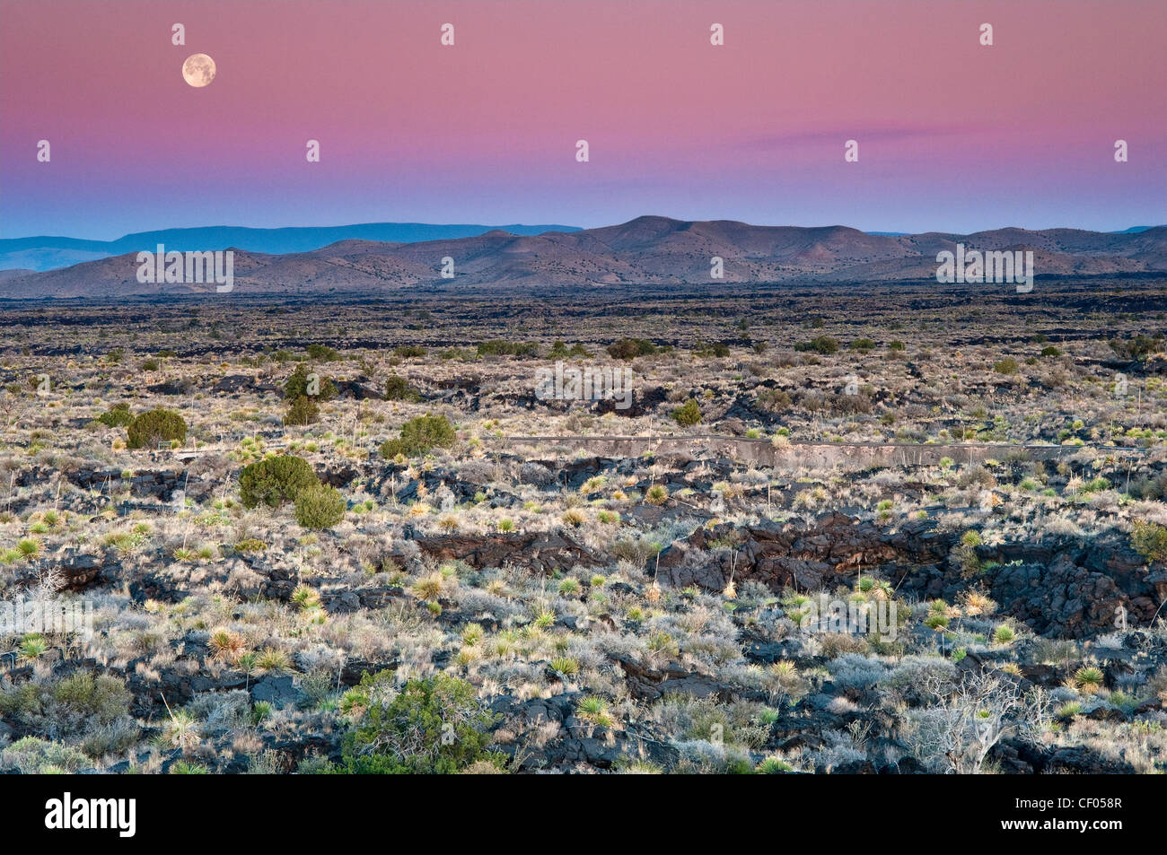 Moon setting down at sunrise over Carrizozo Malpais lava field, Valley