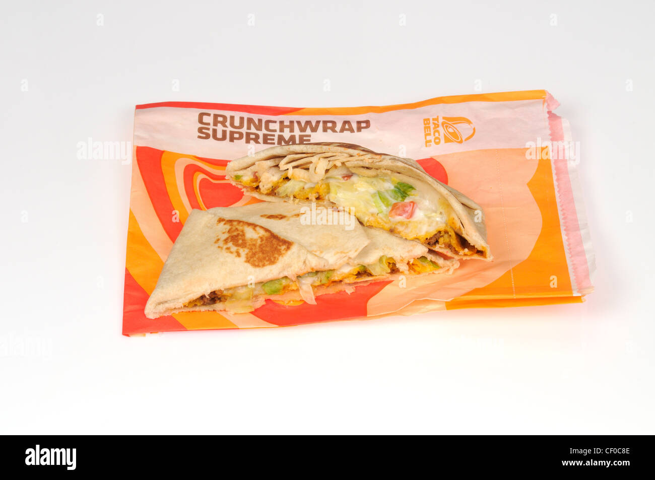 Taco Bell crunchwrap supreme tortilla cut in half on wrapper on white background cutout  USA Stock Photo