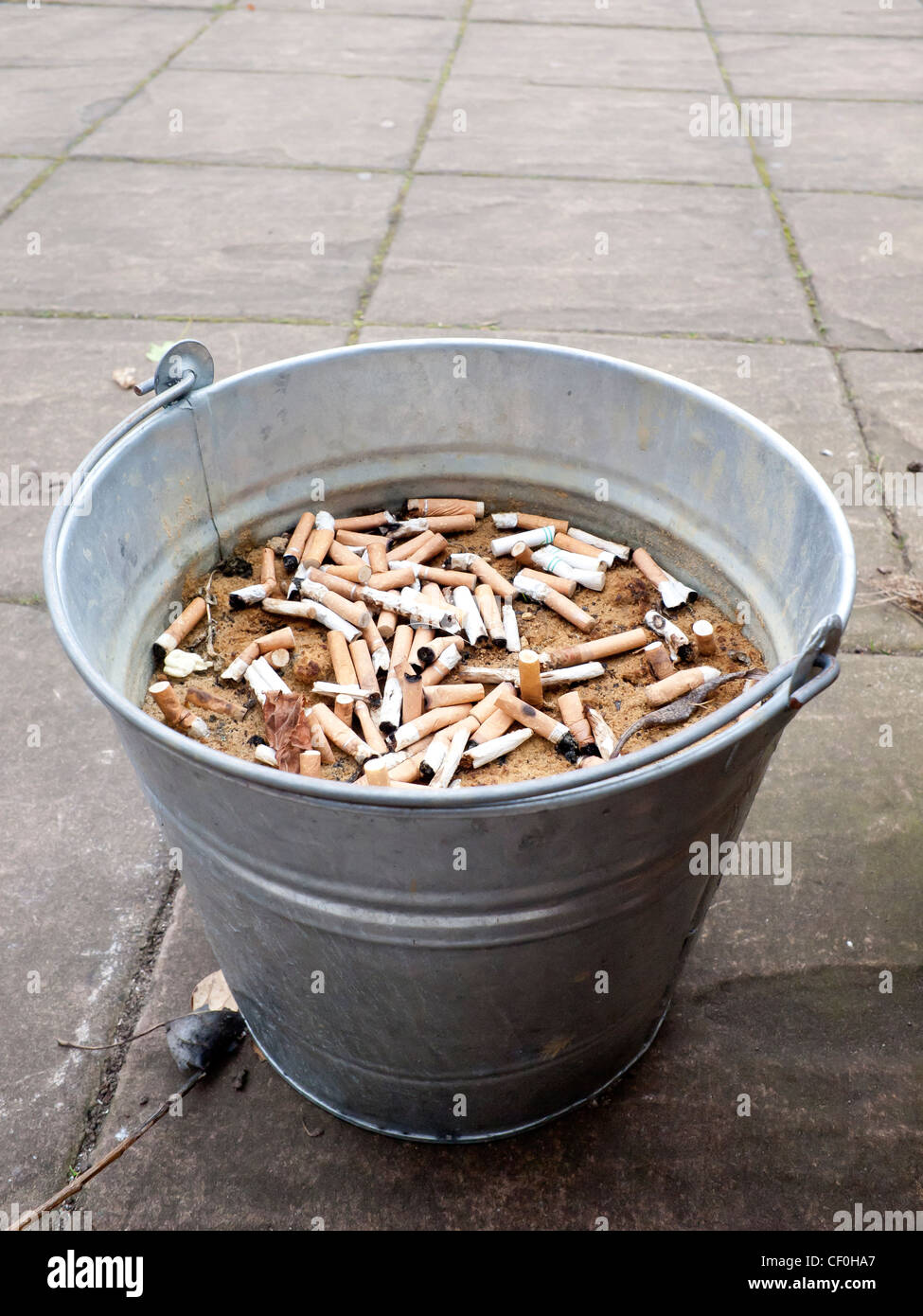 A traditional galvanised iron bucket filled with sand and used for