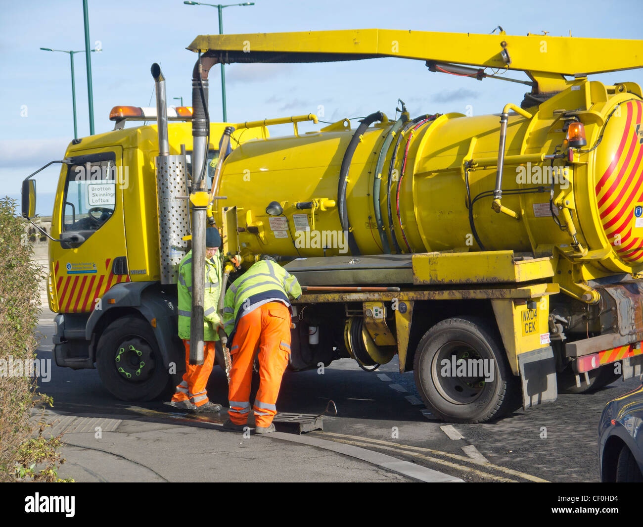 Two council workmen using a sewer cleaning truck to flush and clean