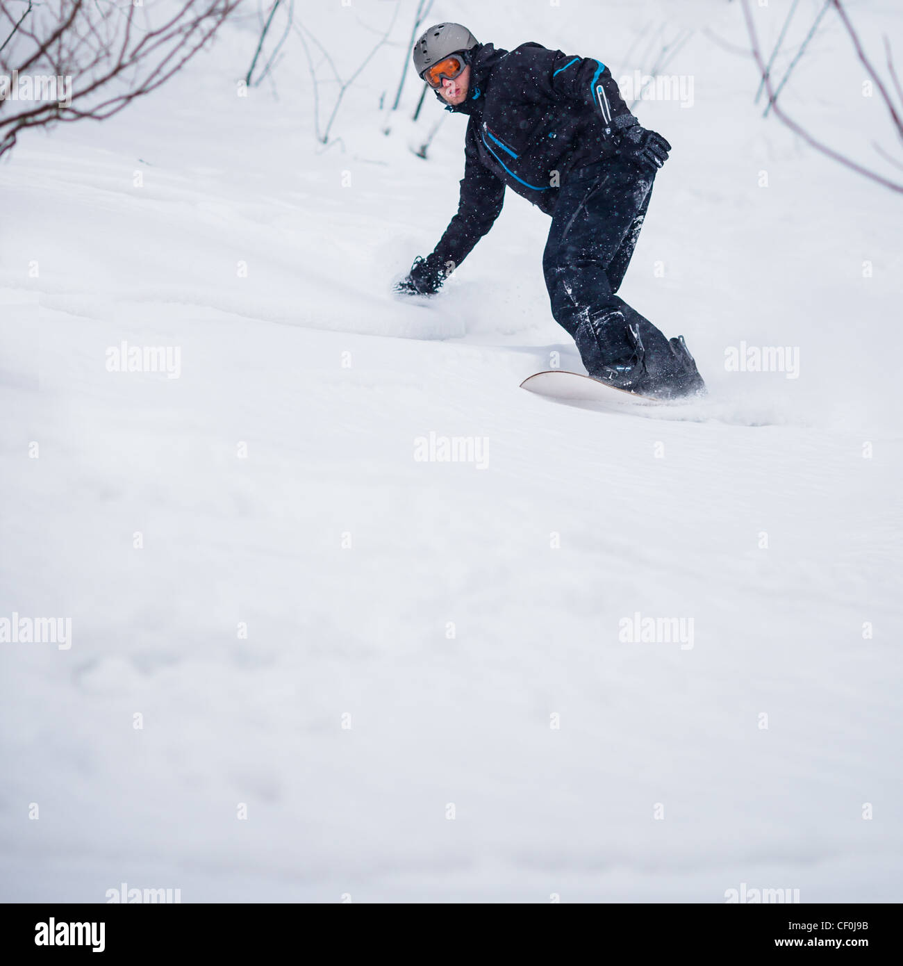 Young man freeride snowboarding offpiste in a mountain resort on a