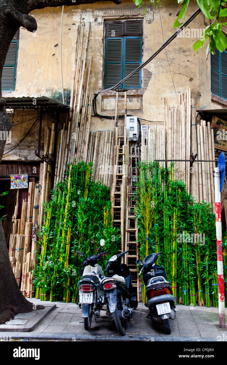 Three motorbikes in front of fake bamboo branches, Hanoi, Vietnam Stock Photo