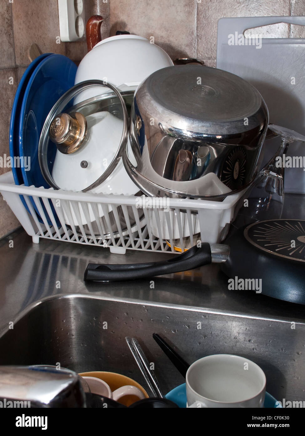 https://c8.alamy.com/comp/CF0K30/plastic-kitchen-drain-dish-rack-full-with-untidy-dishes-and-utensils-CF0K30.jpg