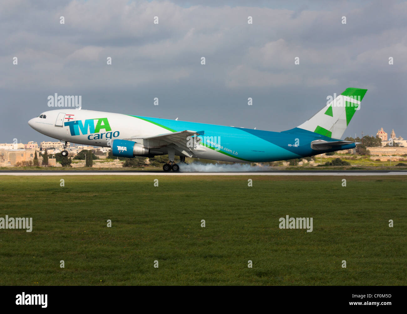 TMA Cargo Airbus A300-600F jet plane touching down on the runway and generating tyre smoke while landing at Malta Airport. Commercial air transport. Stock Photo