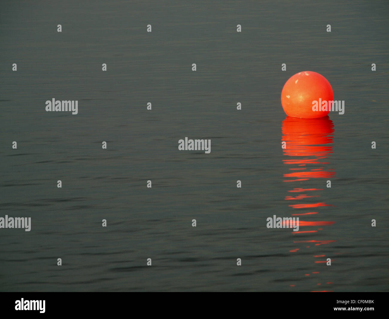 An orange mooring buoy in a calm sea Stock Photo
