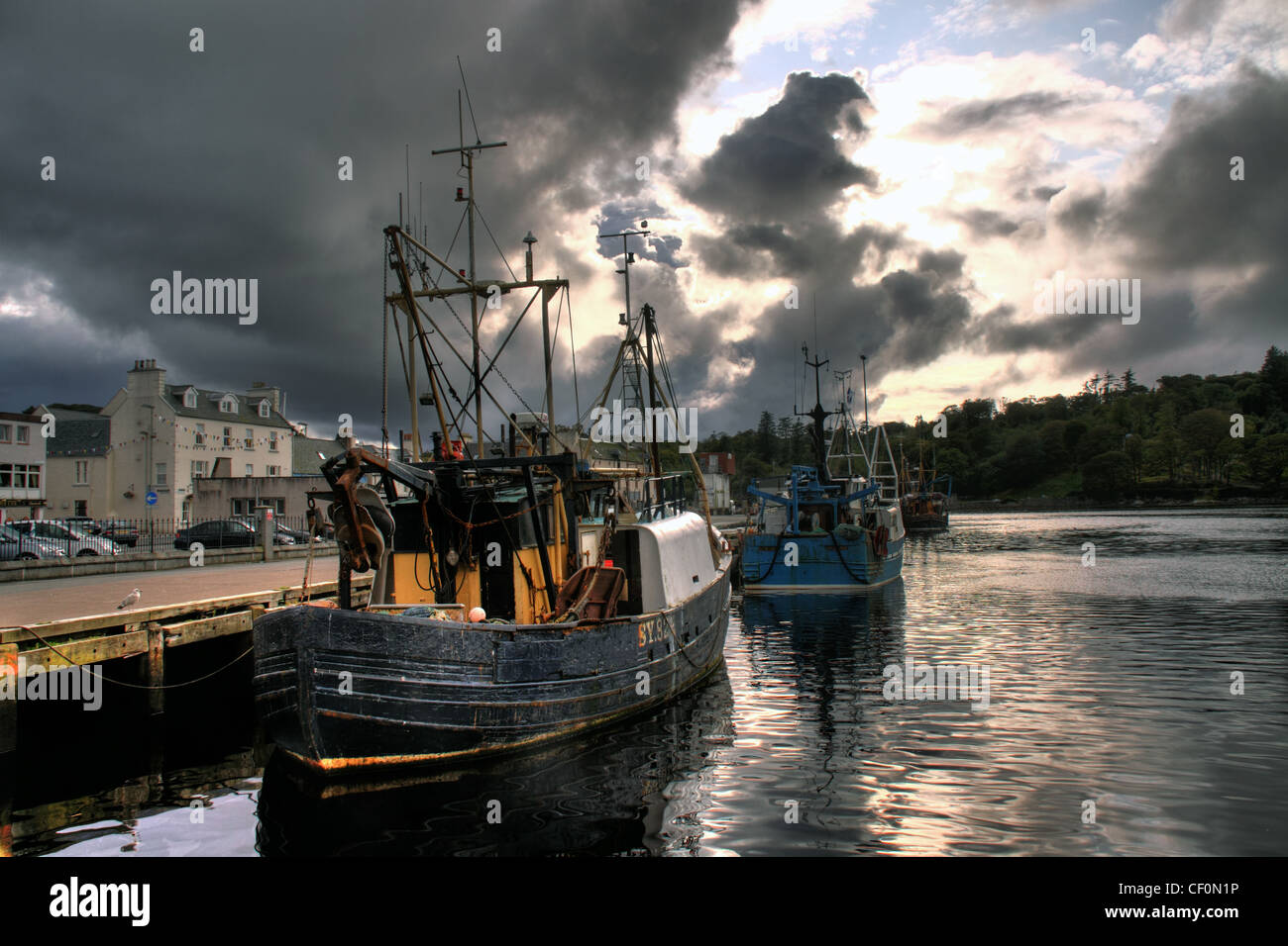 Fishing boats moored at Stornoway Harbour under dramatic evening skies, Isle of Lewis, Outer Hebrides, Scotland. Stock Photo
