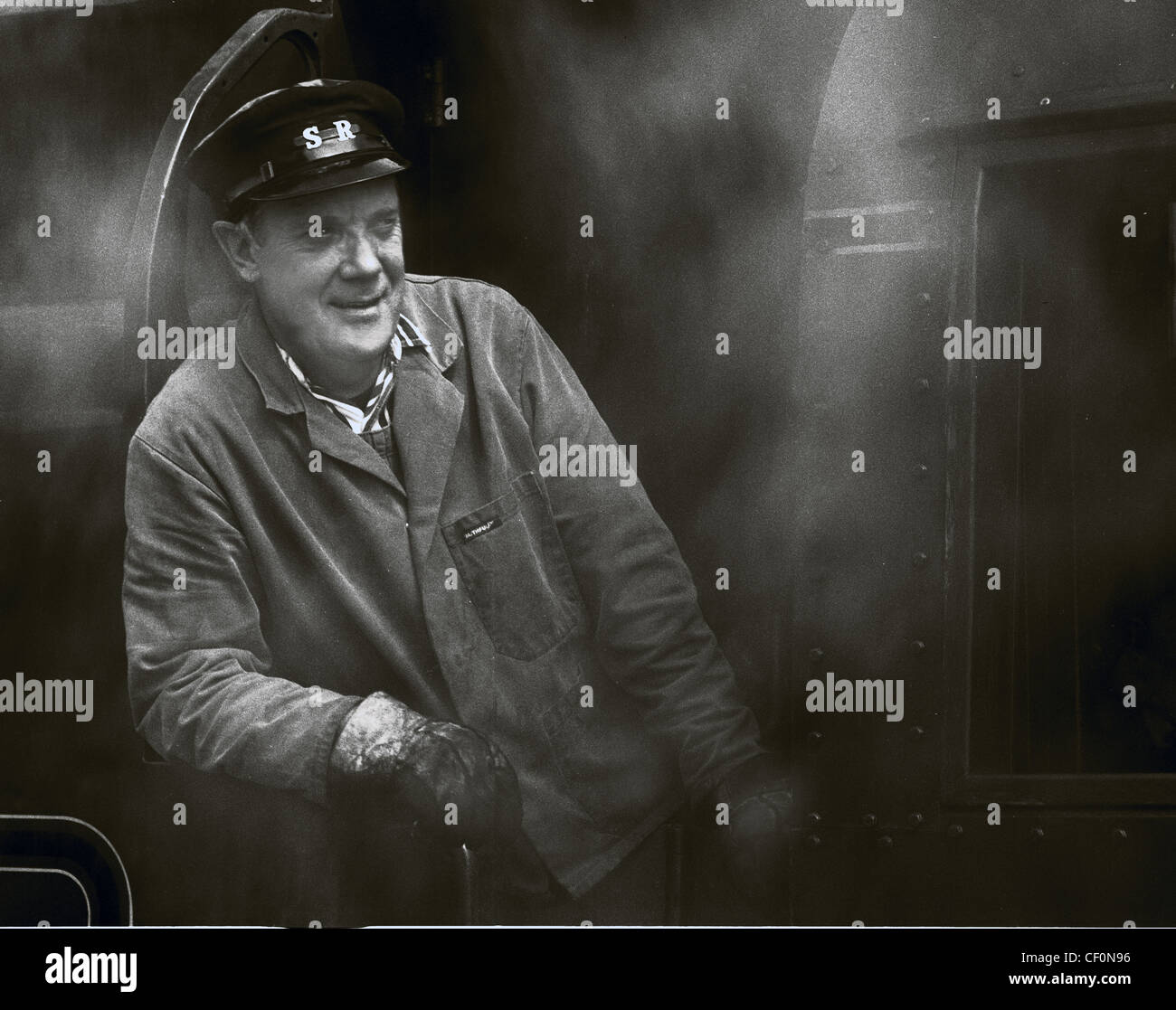 Steam train driver, on the Swanage Railway, Dorset, South West England, UK, in monochrome Stock Photo