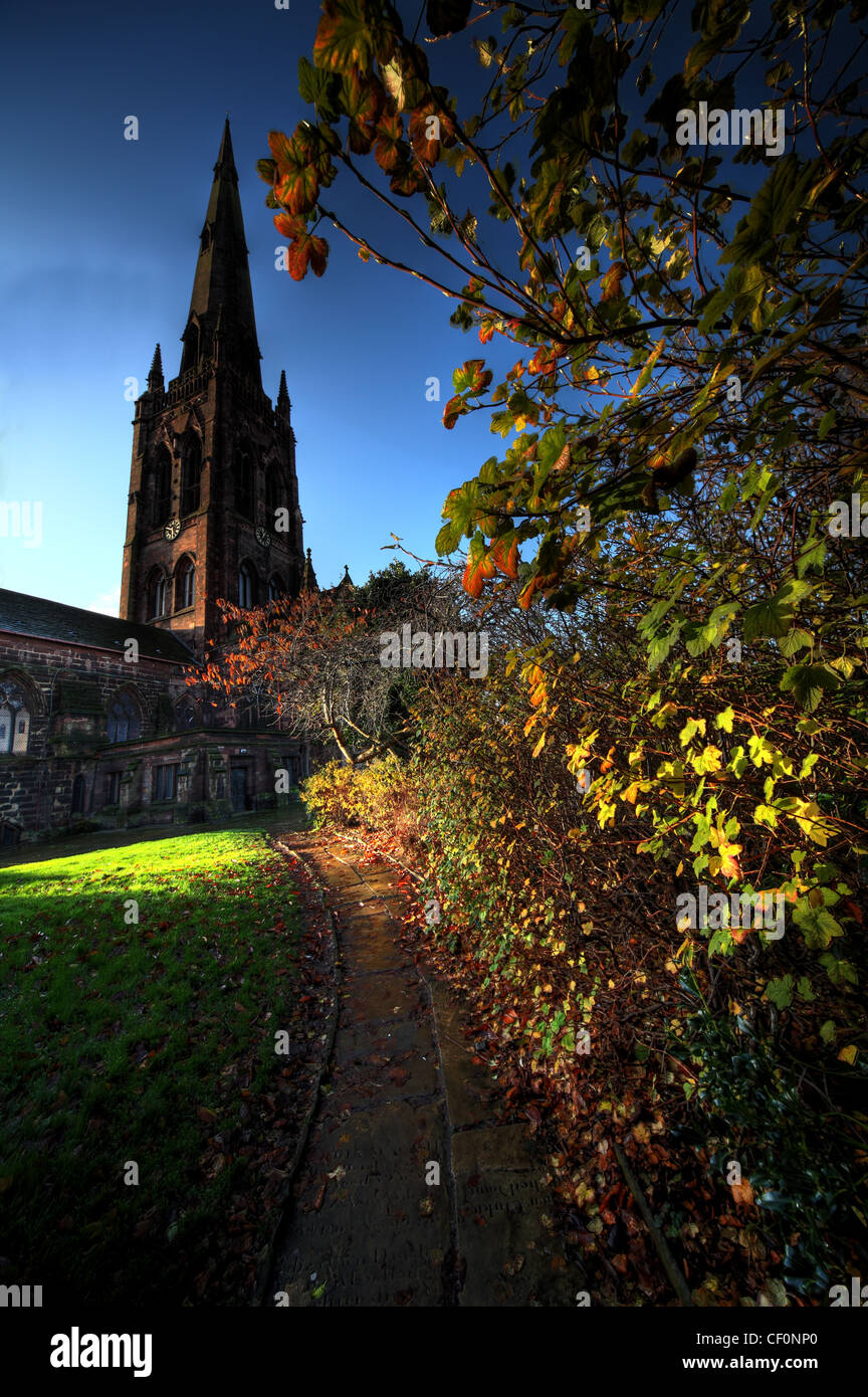 Up the path to Warrington St Elphins church showing its spire on an autumn morning Stock Photo