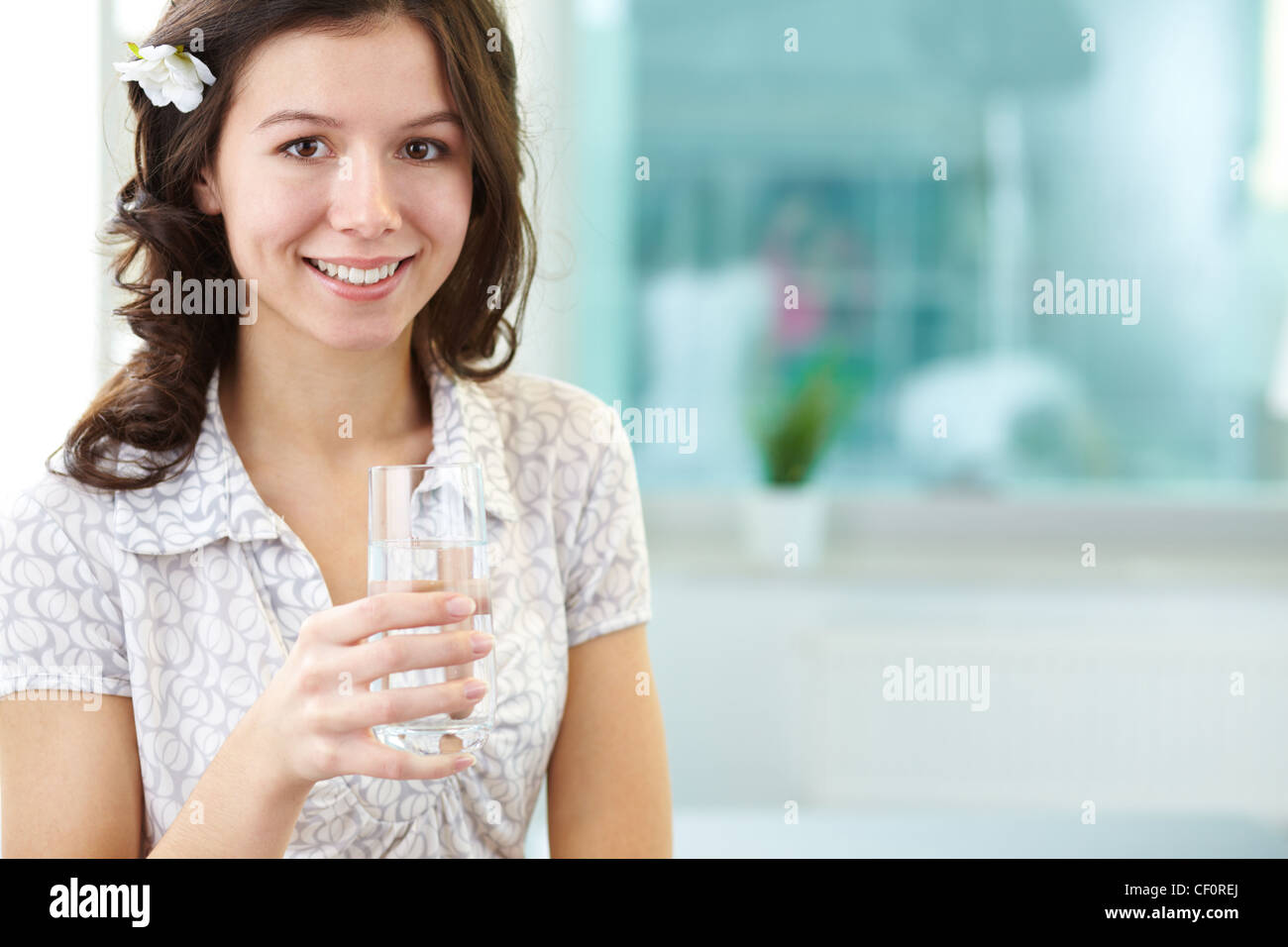 Smiling woman with a glass of water looking at camera Stock Photo - Alamy