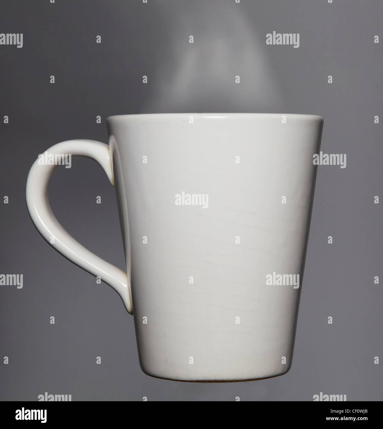 Mug of hot drink against grey Stock Photo