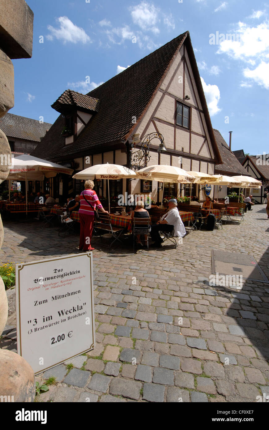 Visitors are having lunch at the Restaurant Bratwurstglocklein in the medieval village of the Handwerkerhof (Tradesmen's court) in Nuremberg, Germany. Stock Photo