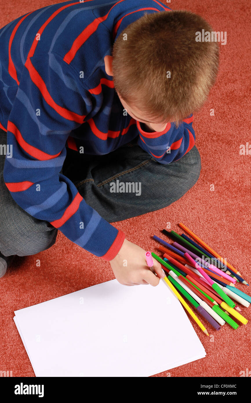 Boy Using Paper young boy sits with his pencils and paper Stock Photo - Alamy
