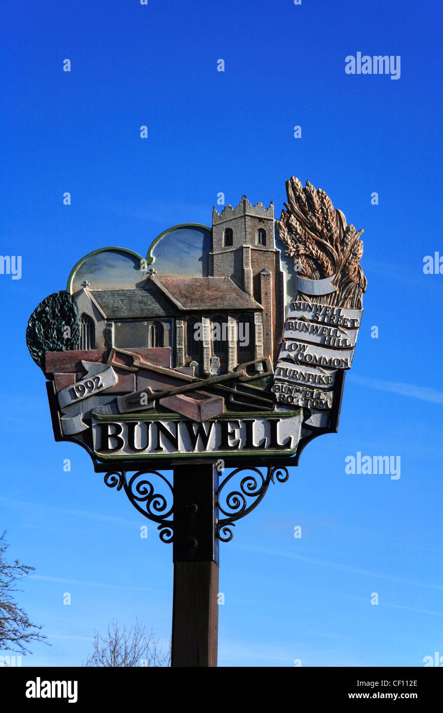 A portrait of the village sign at Bunwell, Norfolk, England, United Kingdom, against a deep blue sky. Stock Photo