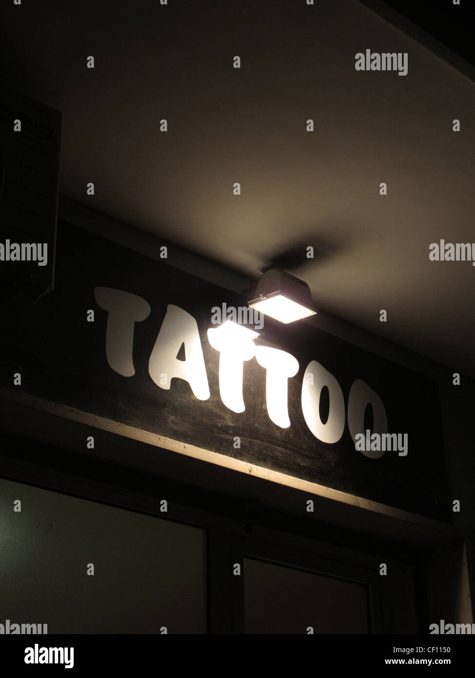 tattoo shop sign notice at night Stock Photo - Alamy