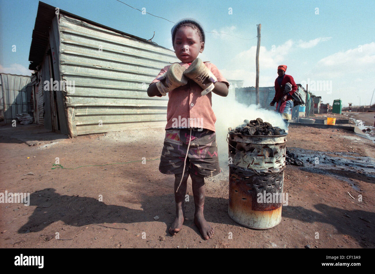 Barefoot Township kid in Soweto, South Africa uses shoes to keep his ...