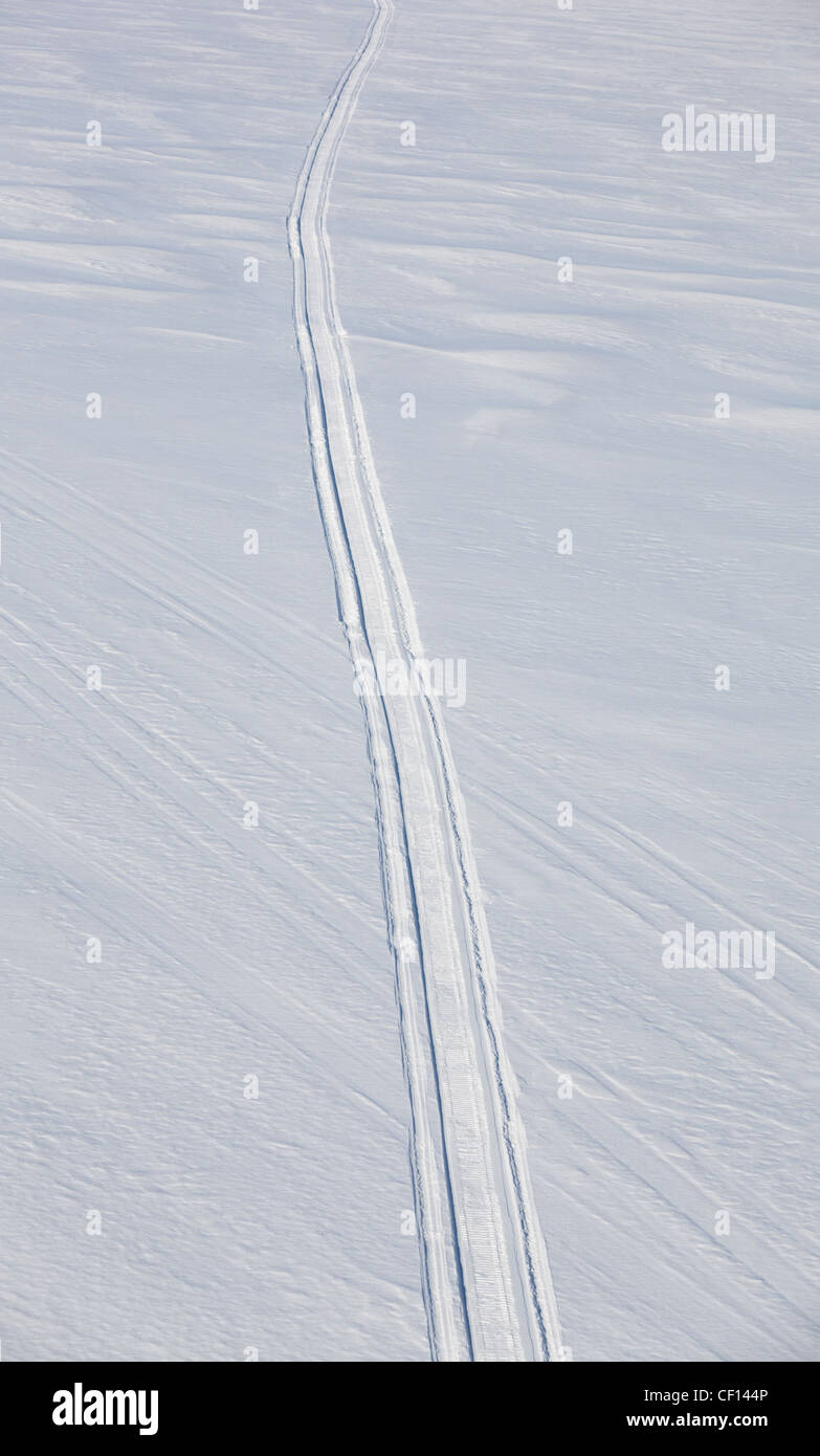 Aerial image of a single isolated snowmobile track on untouched snow at lake ice , Finland Stock Photo