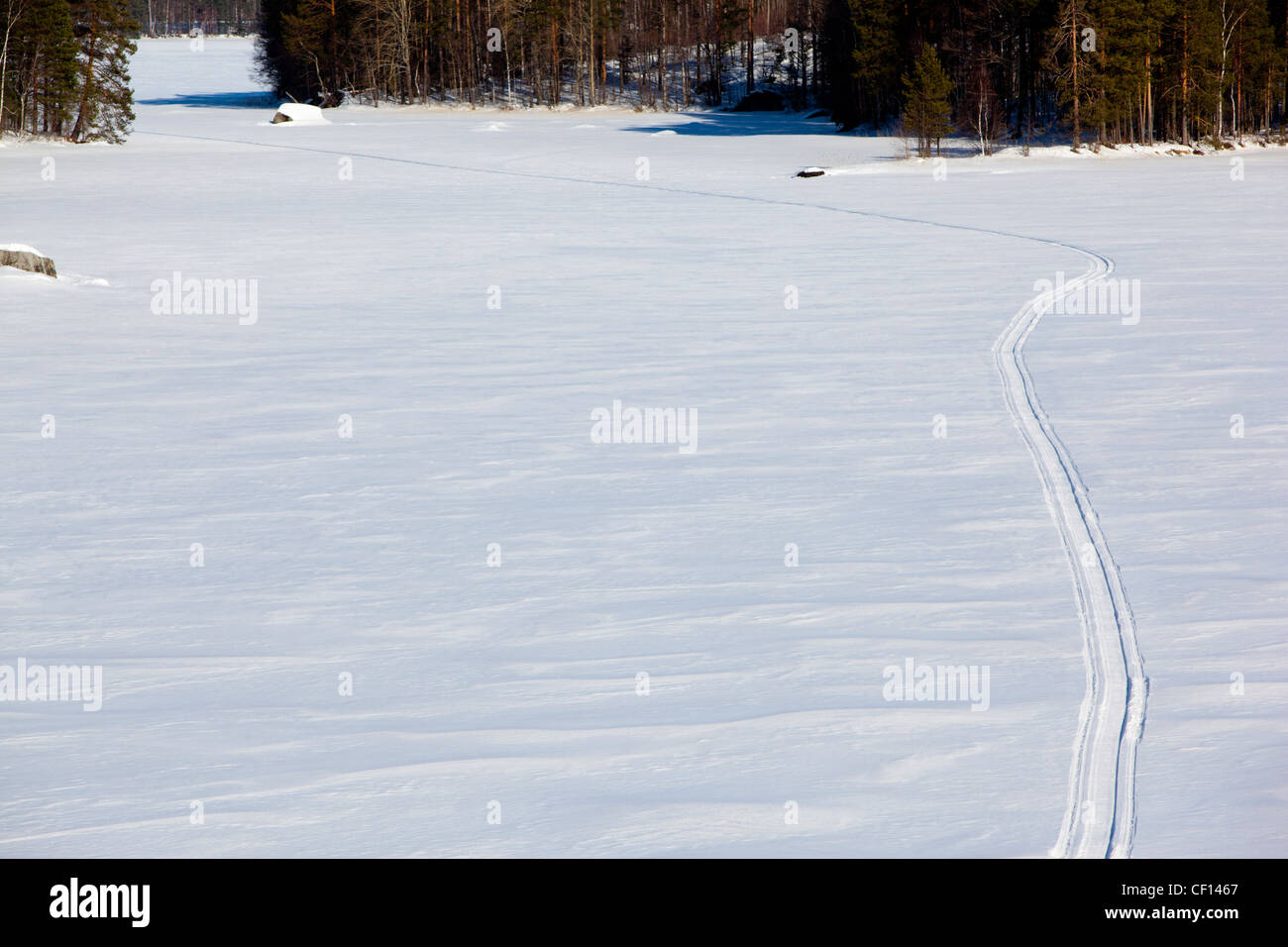 Isolated snowmobile trail on snow and lake ice , Finland Stock Photo