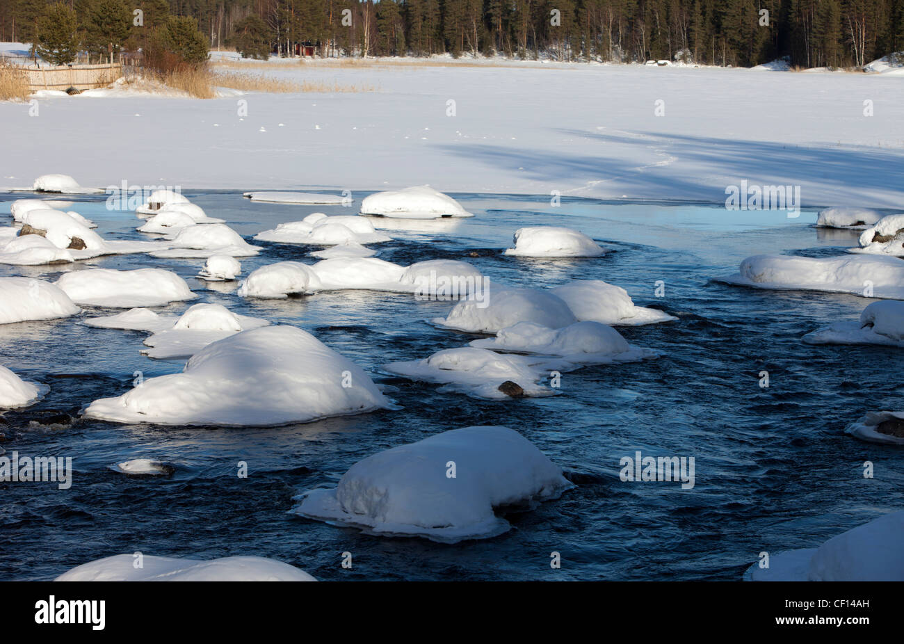 Snowy rocks in river , Finland Stock Photo