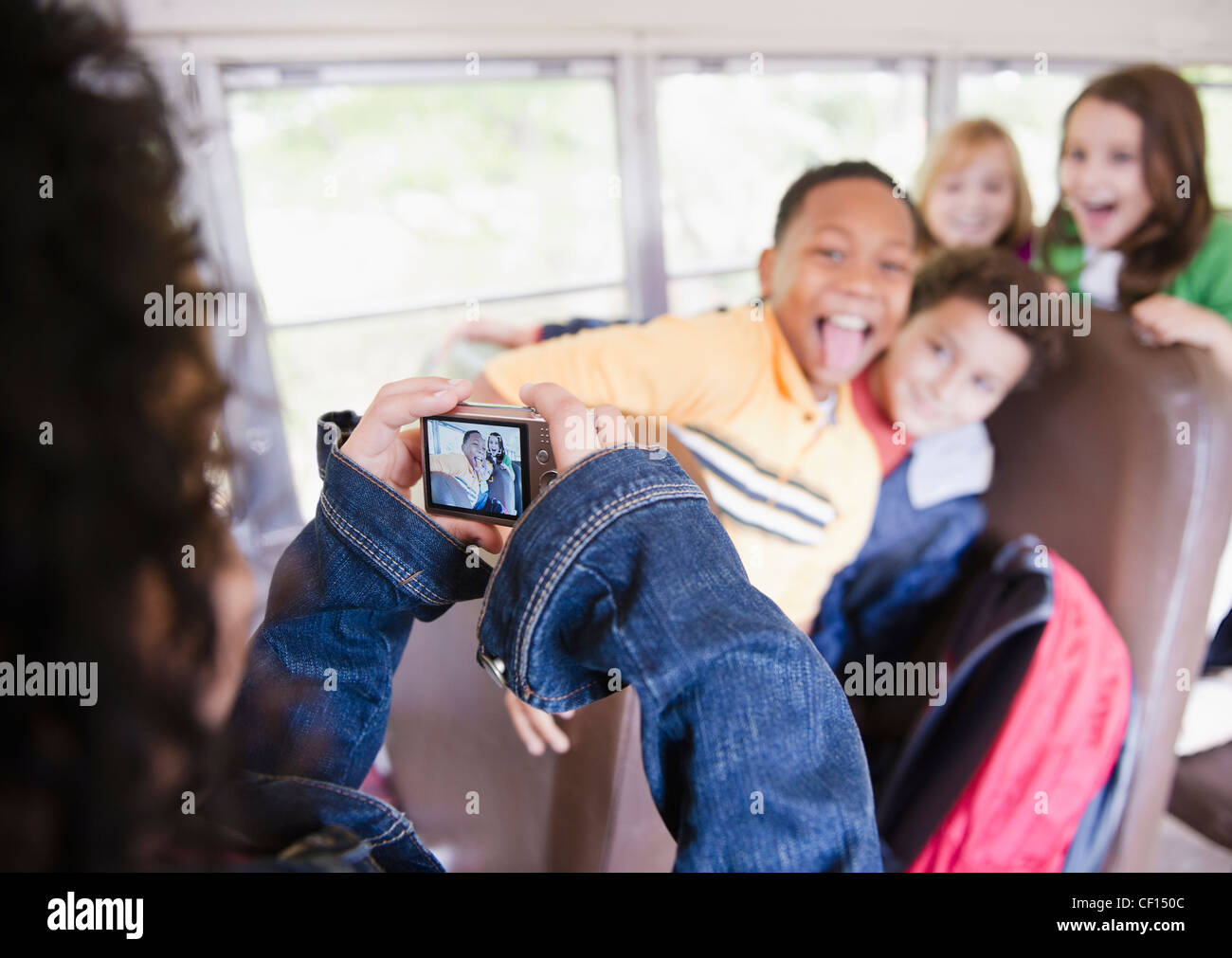 Girl taking photographs on school bus Stock Photo