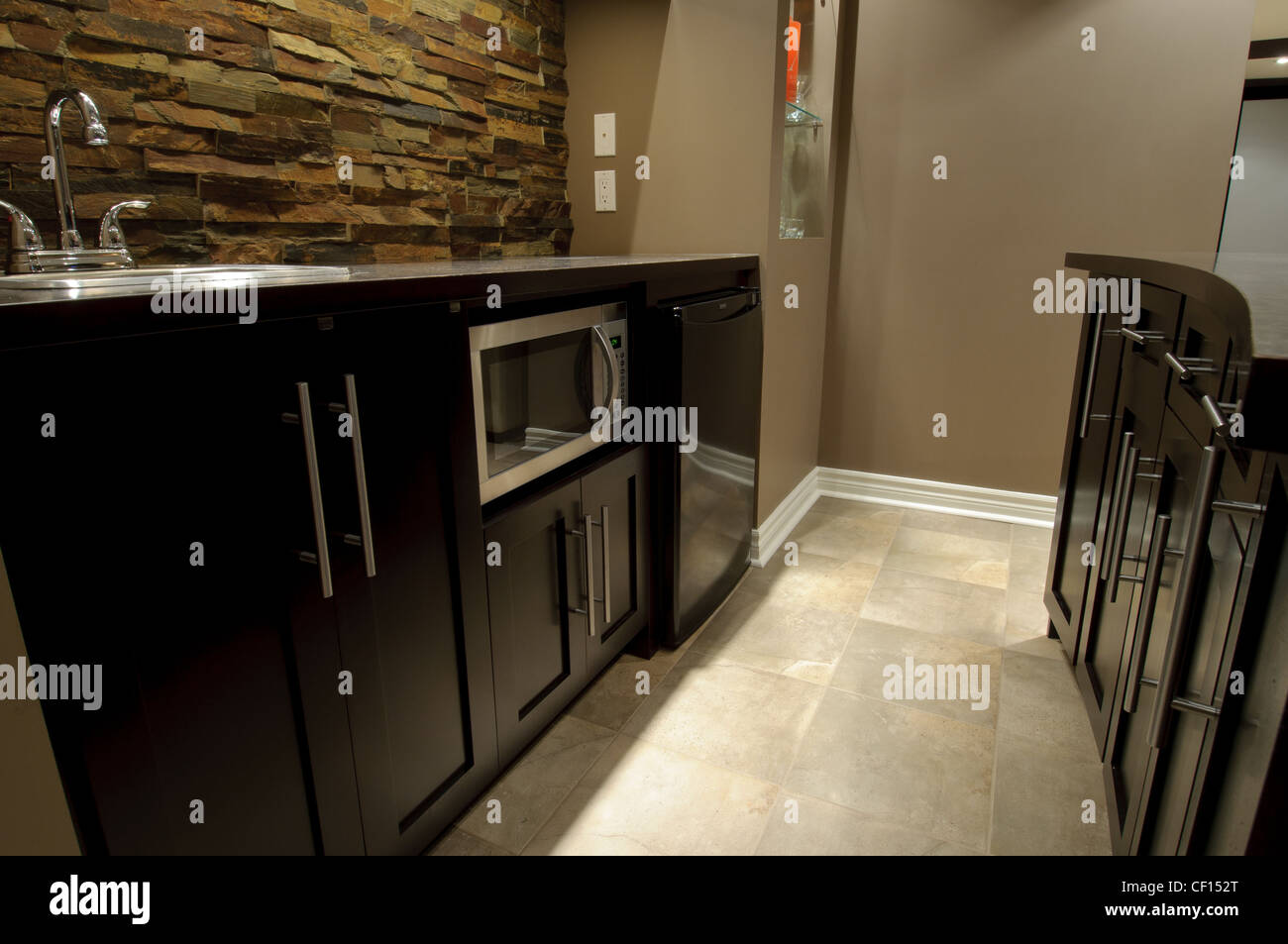 Luxurious residential basement bar with microwave and fridge. Stock Photo