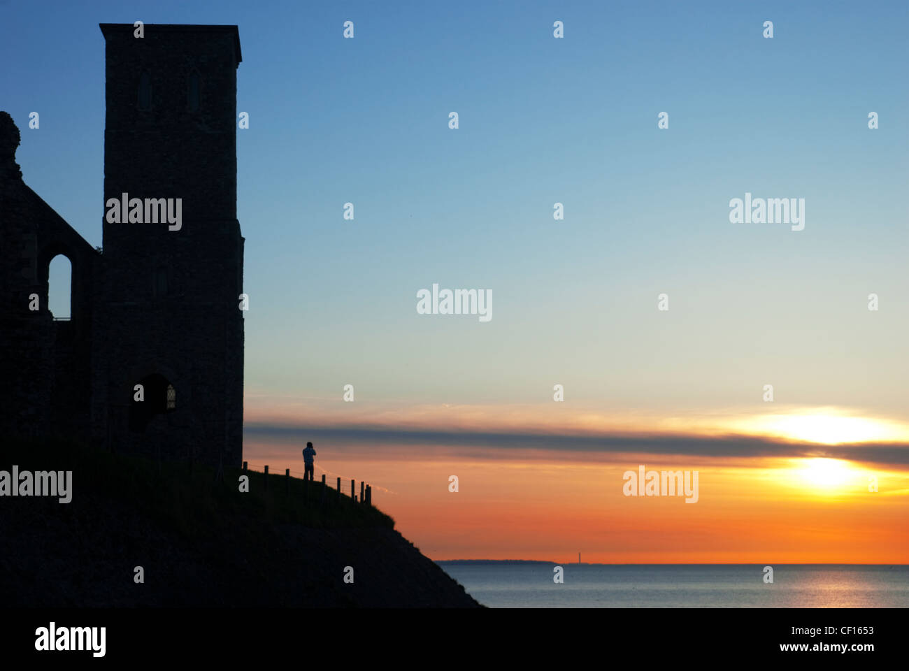 A lone figure at sunset beneath the Reculver Towers in Kent Stock Photo
