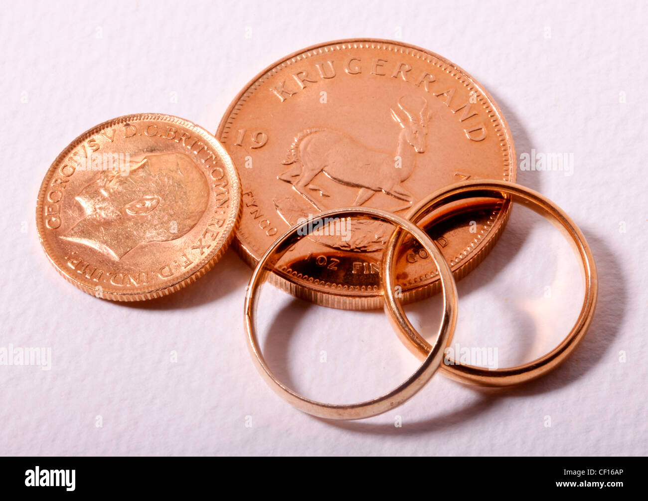 GOLD KRUGERRAND, GOLD SOVEREIGN COINS AND WEDDING RINGS Stock Photo