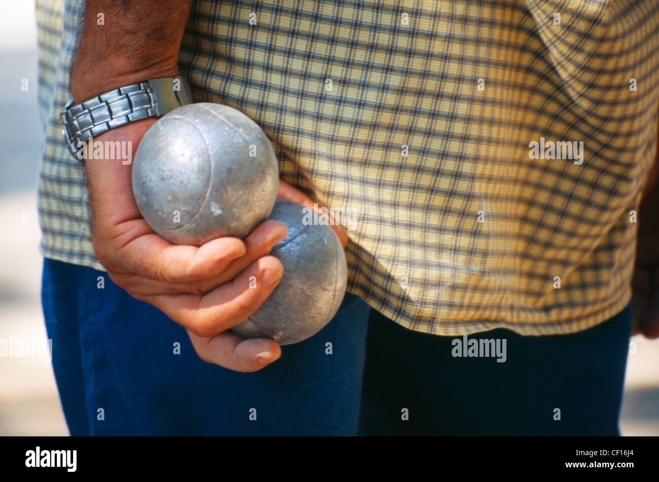 A Frenchman clutches his boules during a game of this traditional French sport. Stock Photo